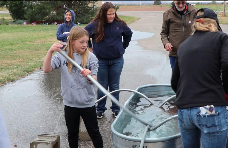 Youth use irrigation pipe at hands-on demonstration