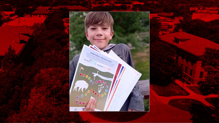 boy holding sheets of paper