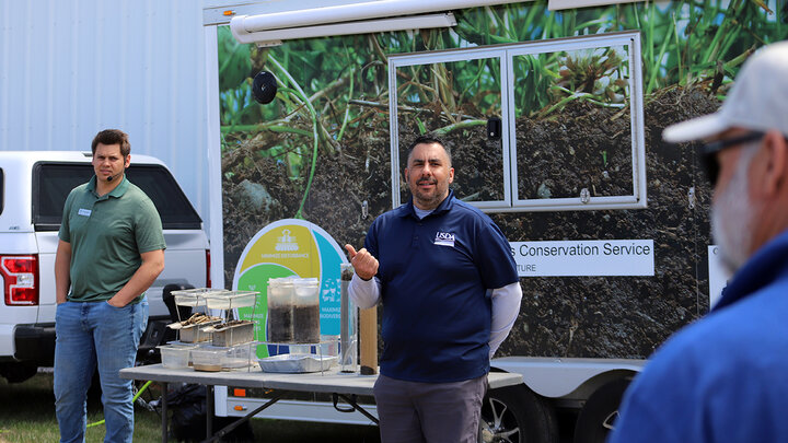 two men in front of land and water display