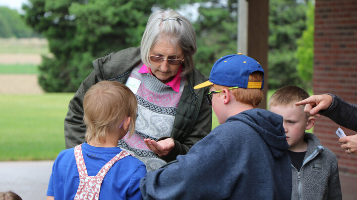 women handing out seeds to children