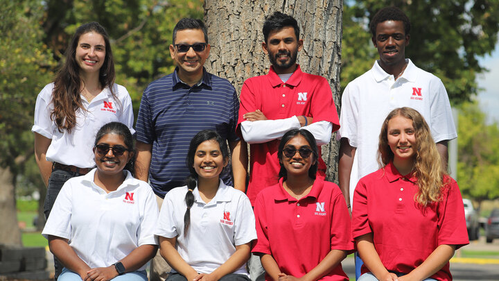 seven people, men and women pose for photo