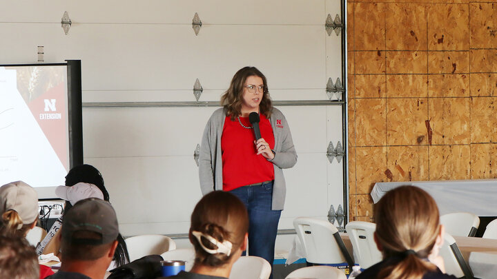 woman speaking with mic in front of people at a workshopf