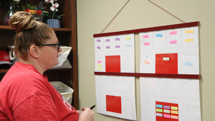 women looking at calendar schedule on wall