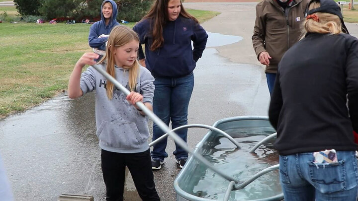 Lake Minatare, fifth-grader Brooklynn Luikens, took a turn at setting an irrigation pipe. Waiting their turn was Micheala Ashing, left, and Addison Reuter.