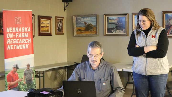 man loads presentation on computer while a woman watches