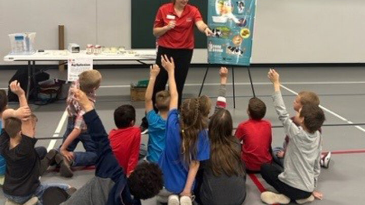 woman talking with elementary students