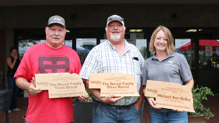 two men and a woman holding awards