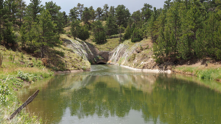 water comes out of a tunnel in side of hill