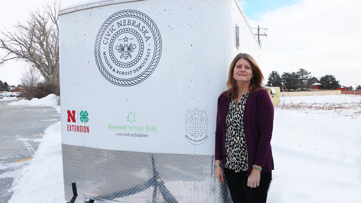 woman stands next to white trailer outside