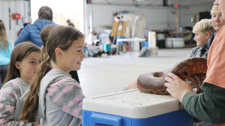 two girls look at pet snake 